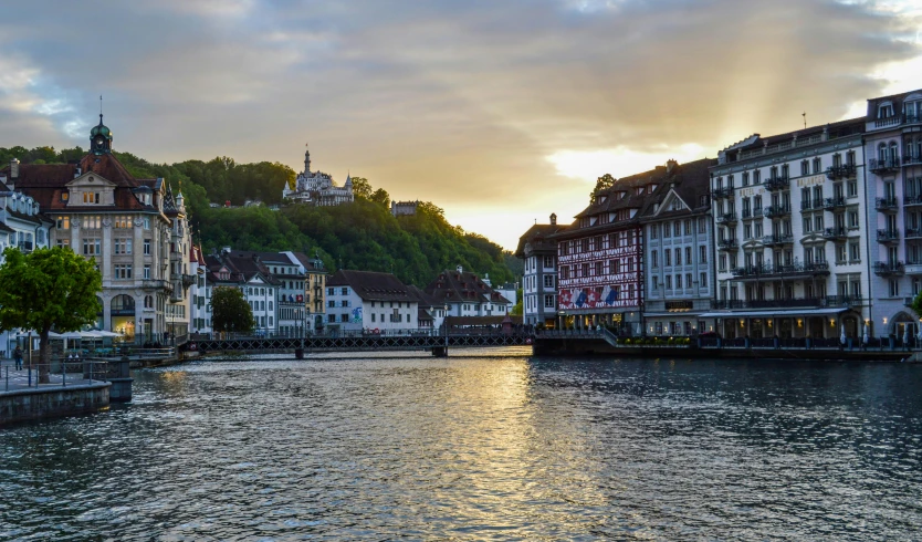 a river running through a city next to tall buildings, by Karl Stauffer-Bern, pexels contest winner, renaissance, summer sunset, viewed from the harbor, gray, youtube thumbnail