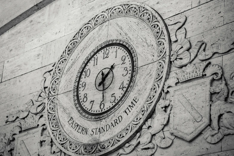 a clock that is on the side of a building, a black and white photo, by Kristian Zahrtmann, pexels, art nouveau, made of carrara marble, etched inscriptions, metropolitan museum photo, 1970s photo