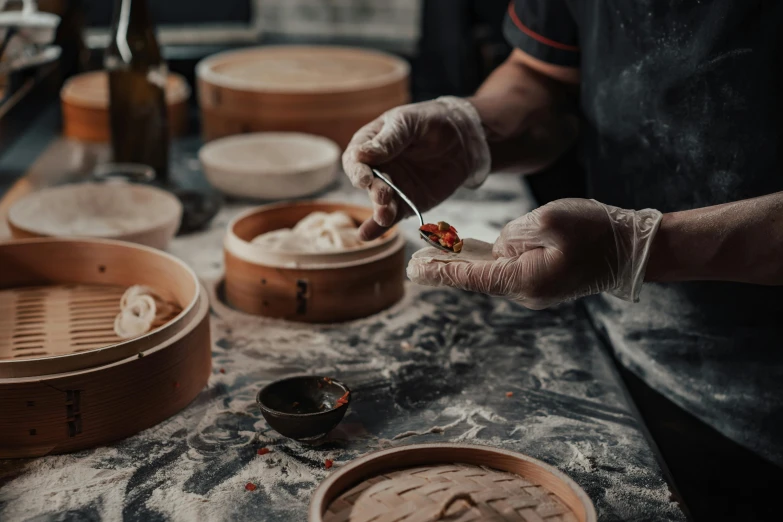 a person holding a spoon over a bowl of food, steamed buns, stitching, small manufacture, 🦩🪐🐞👩🏻🦳