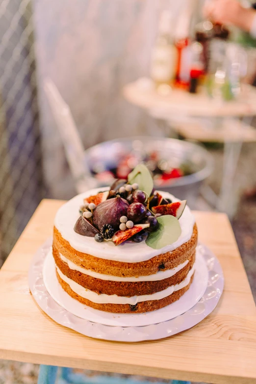 a cake sitting on top of a wooden table, a pastel, botanicals, fruit, gourmet style, on display