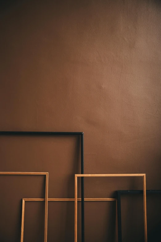 a couple of frames sitting next to each other, a minimalist painting, inspired by Donald Judd, trending on unsplash, brown:-2, metallic paint, brown color, benches