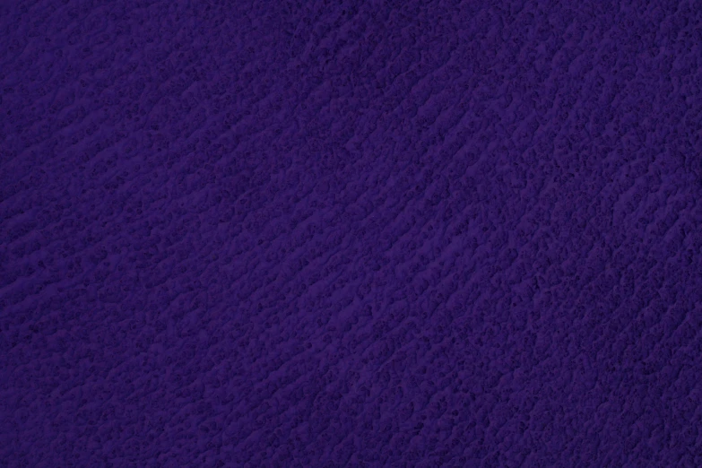 a close up of a purple blanket on a bed