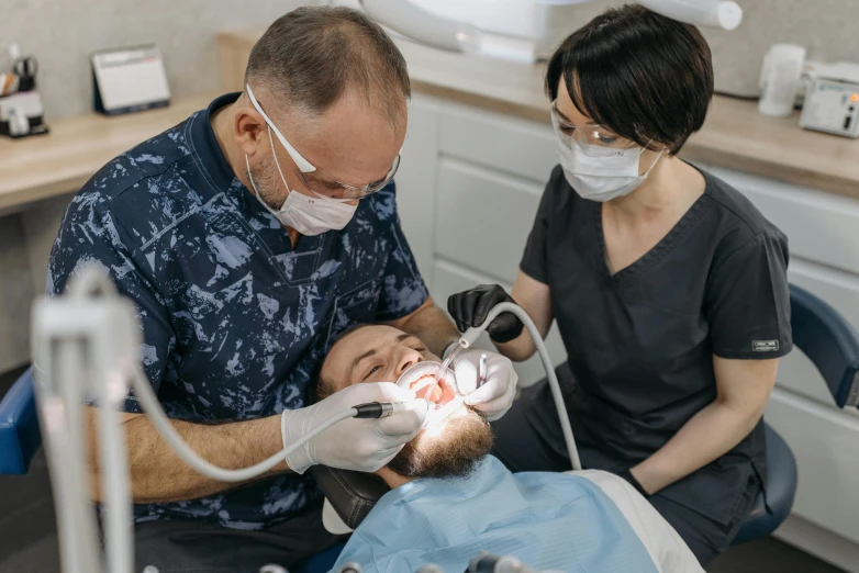 a man getting his teeth examined by a dentist, by Adam Marczyński, pexels contest winner, hurufiyya, melbourne, thumbnail, group photo, falling out of the face