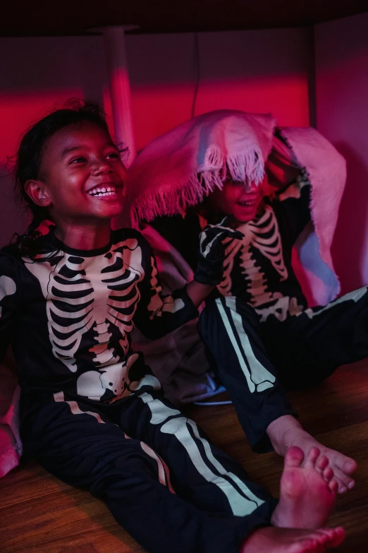 a couple of kids sitting on top of a wooden floor, glowing bones, animatronics, slide show, riyahd cassiem