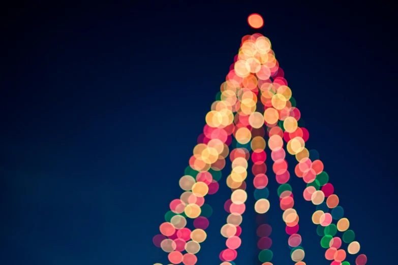 a brightly lit christmas tree against a blue sky, pexels, minimalism, soft pink lights, square, dancing lights, 4 5 mm bokeh