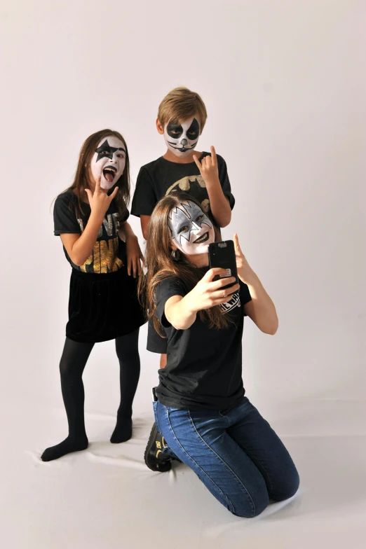 a couple of kids that are posing for a picture, black metal face paint, photoshoot for skincare brand, family photo, taking a picture