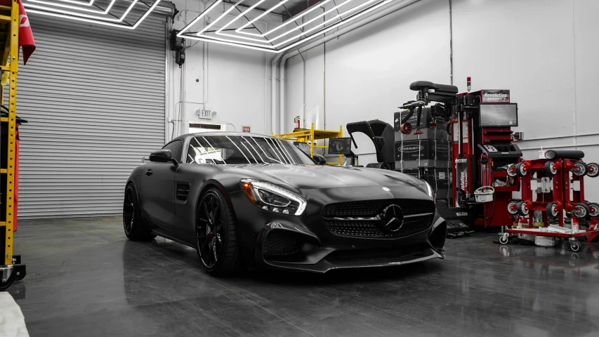 a black and white photo of a car in a garage, matte paint colors, mercedes, brushed rose gold car paint, racecar