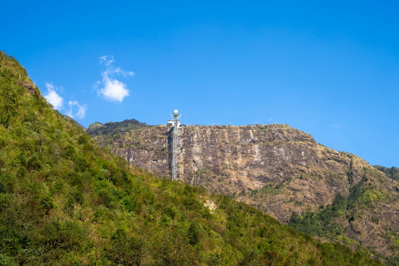 a statue of jesus on top of a mountain, a statue, sri lankan landscape, slide show, seen from a distance, silo