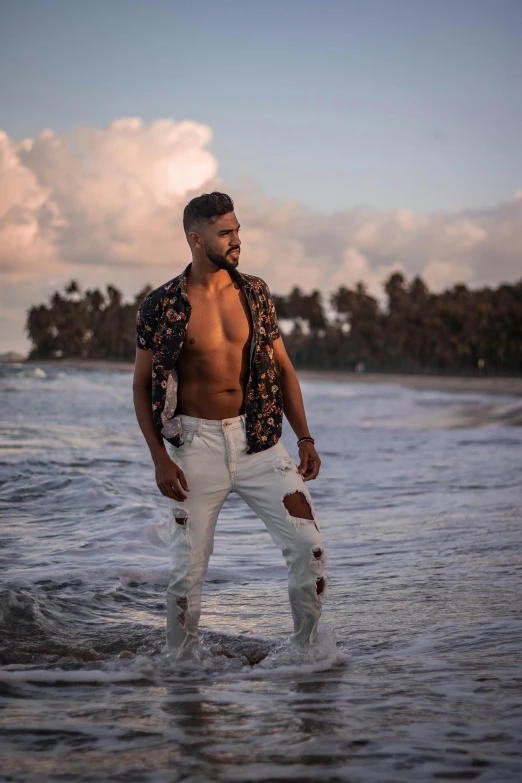 a man that is standing in the water, by Robbie Trevino, posing on a beach with the ocean, luis melo, drake, hispanic