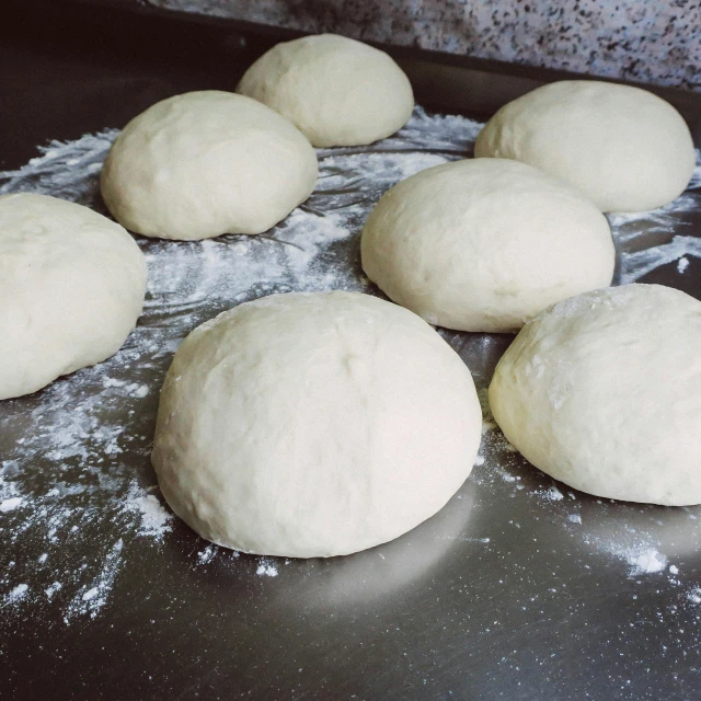 a bunch of dough sitting on top of a counter, round-cropped, 6 pack, plain, polished