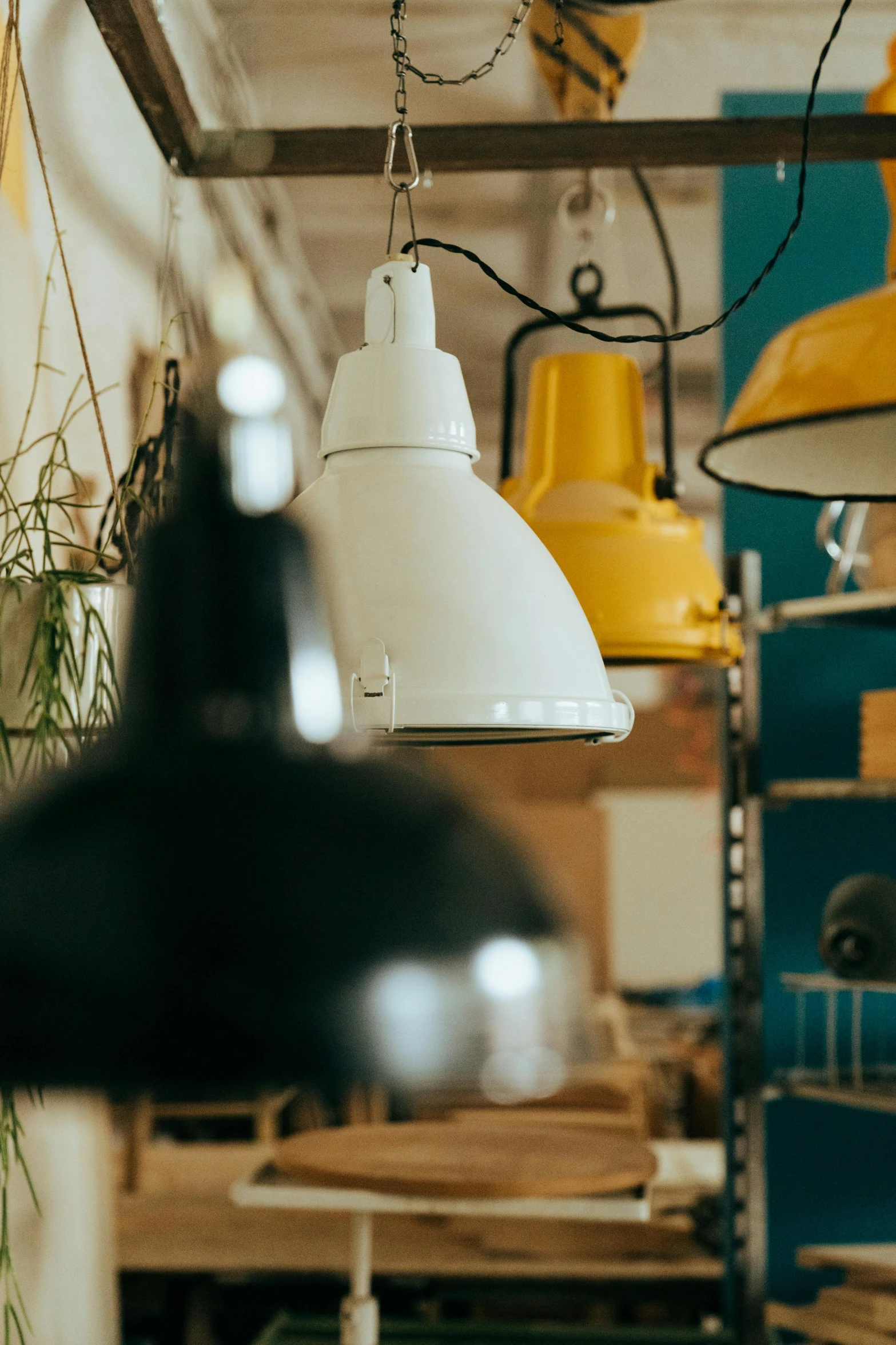 a room filled with lots of lights hanging from the ceiling, trending on pexels, light and space, white wall coloured workshop, industrial colours, large head, blue and yellow lighting