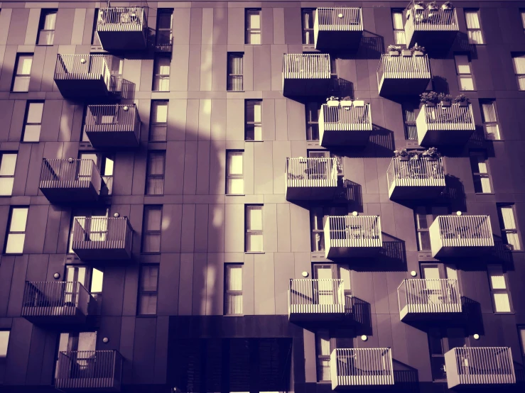 a black and white photo of a building with balconies, a photo, by Lee Loughridge, unsplash, sepia toned, ten flats, platforms, we go