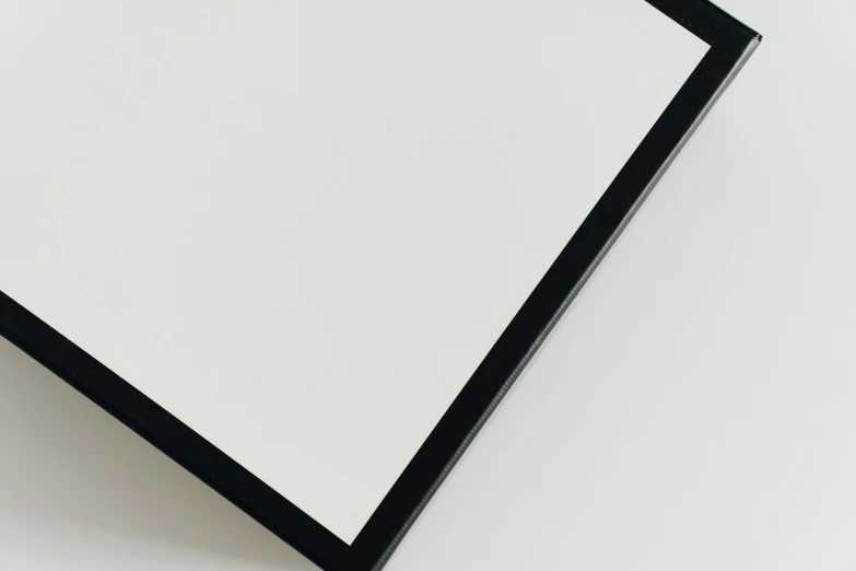 a picture frame sitting on top of a white surface, by Harvey Quaytman, unsplash, black lacquer, soft white rubber, square face, no logo