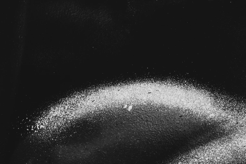 a black and white photo of a person covered in powder, a stipple, by Lucia Peka, unsplash, kinetic pointillism, close up of single sugar crystal, taken in the night, lying on an abstract, glare