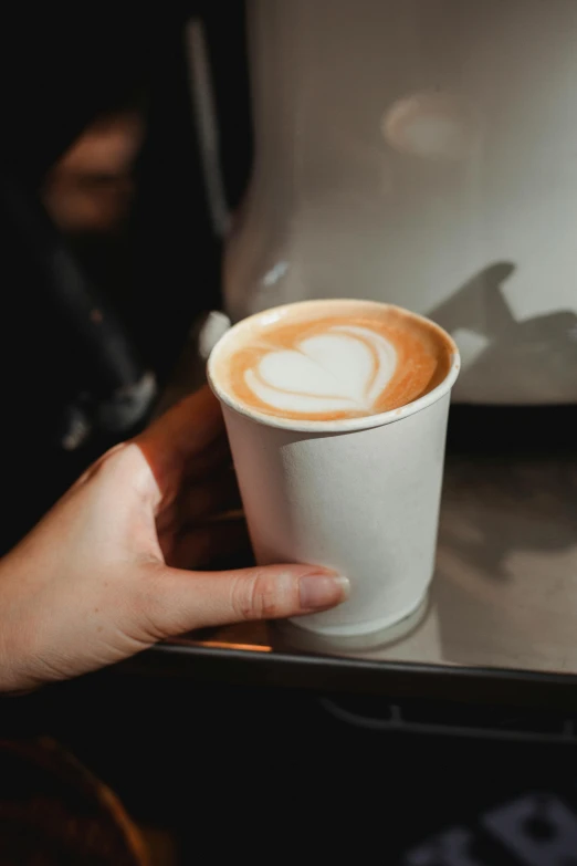 a close up of a person holding a cup of coffee, jen atkin, latte art, high quality product image”, large)}]