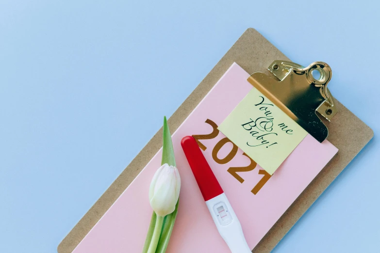 a clipboard with a note and a flower on it, trending on pexels, happening, pink and gold color scheme, contest winner 2021, permanent marker, yearbook photo