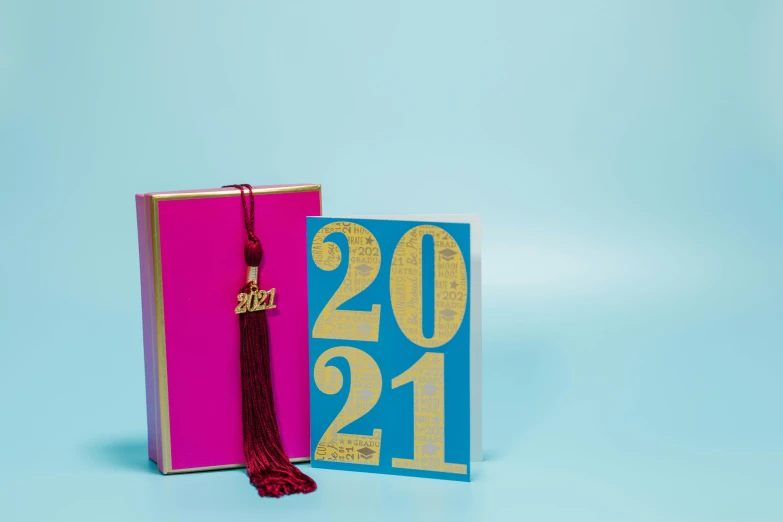 a book with a graduation cap on top of it, an album cover, by Julia Pishtar, fuchsia and blue, gold foil, 27, card