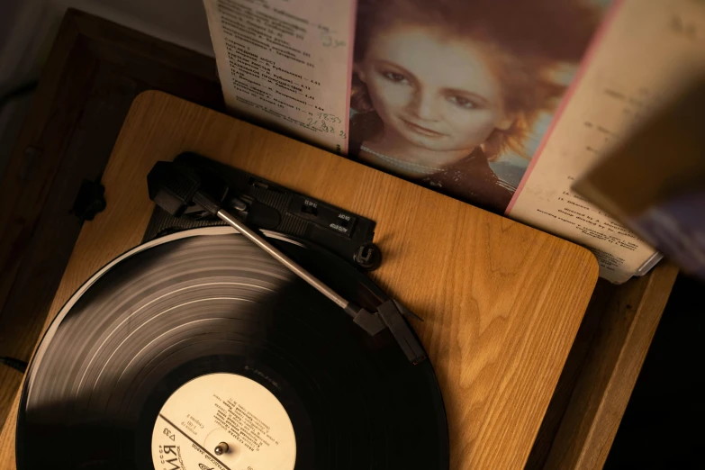 a record sitting on top of a wooden table, inspired by Nan Goldin, trending on pexels, young dolly parton, circa 1 9 8 4, in detail, at home