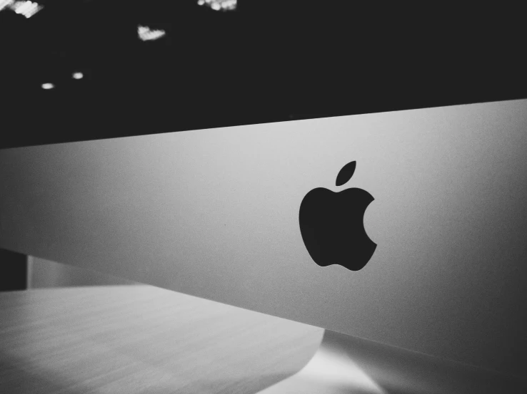 a black and white photo of an apple computer, by Adam Rex, unsplash, logos, glossy surface, low quality photo, apple car