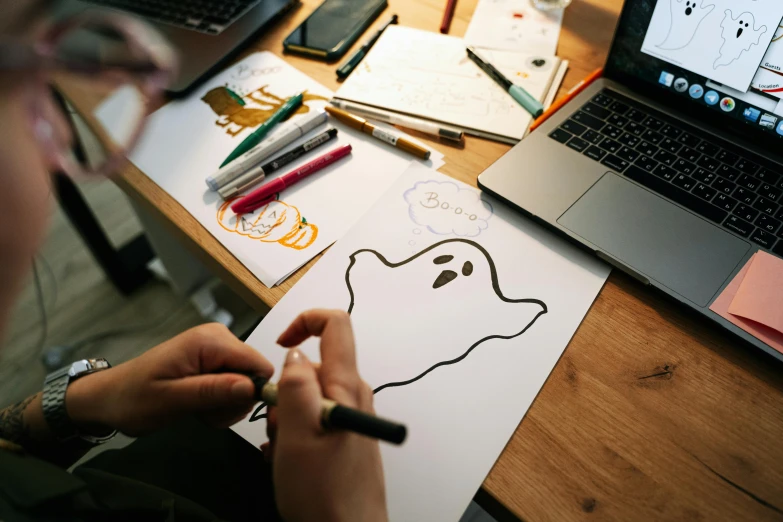 a person drawing a ghost on a piece of paper, a drawing, trending on pexels, costume desig, working on a laptop at a desk, shaped picture, game art