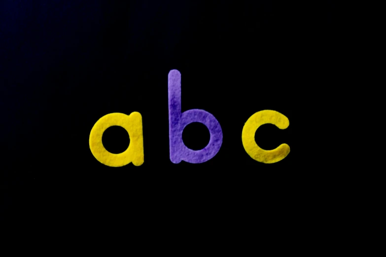 a close up of the letters abcc on a black background, unsplash, yellow purple, children's tv show, profile image, full body shot close up