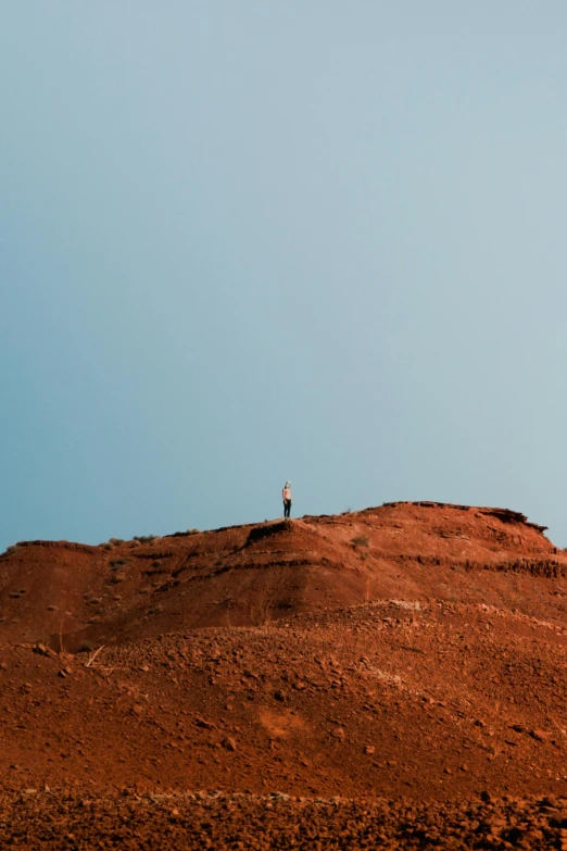 a person standing on top of a red hill, inspired by Scarlett Hooft Graafland, unsplash contest winner, minimalism, rust, kauai, face looking skyward, poop