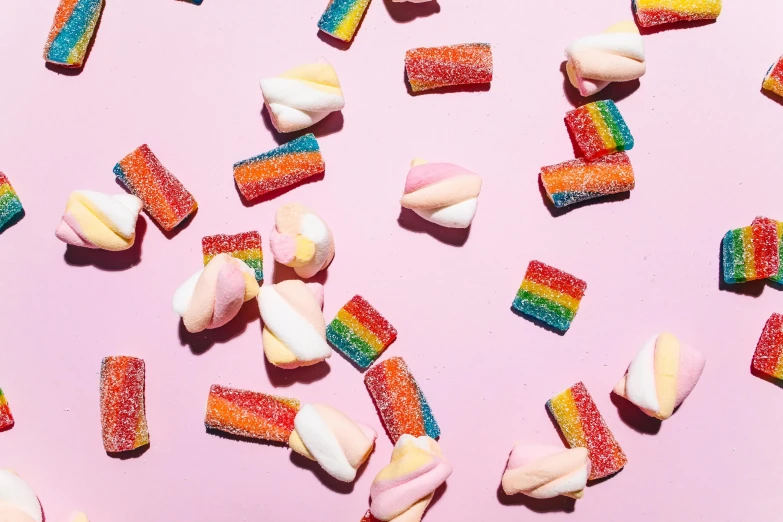 a bunch of candy sitting on top of a pink surface, broken rainbow, jackstraws, pink and orange, subtle detailing