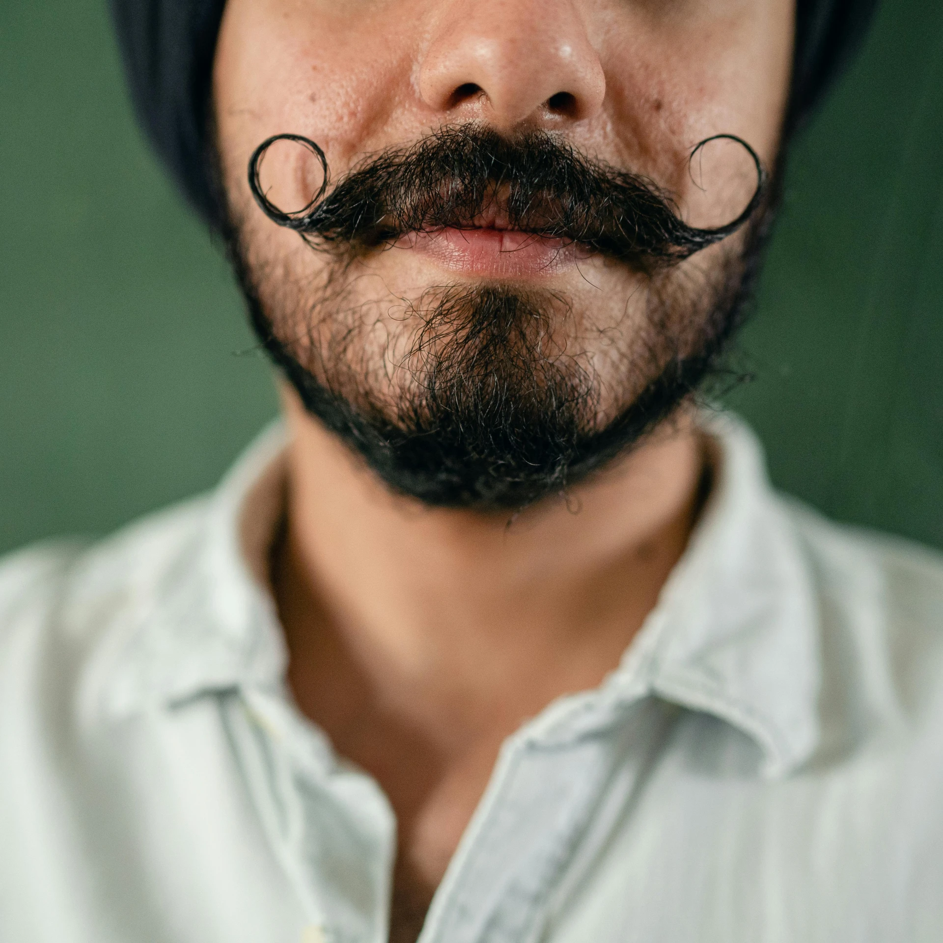 a close up of a man with a mustache, by Julia Pishtar, trending on pexels, renaissance, indian, square masculine facial features, belly button showing, hipster