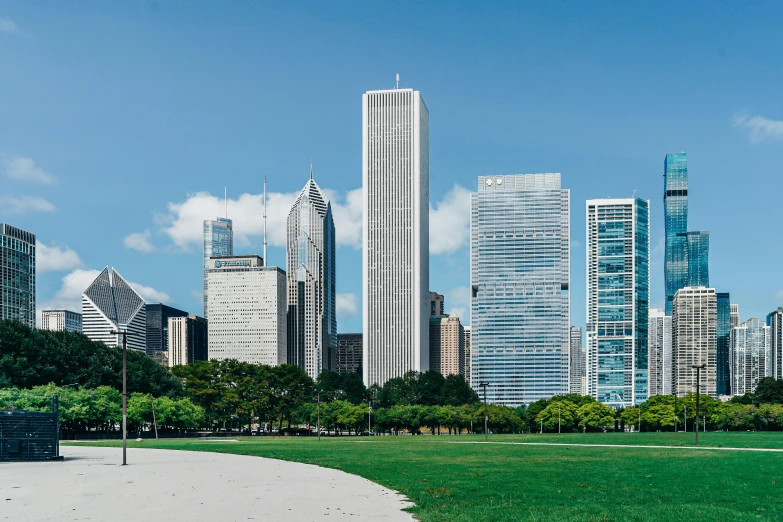 a park filled with lots of green grass next to tall buildings, inspired by Thomas Struth, pexels contest winner, chicago skyline, helio oiticica, monumental structures, from the front