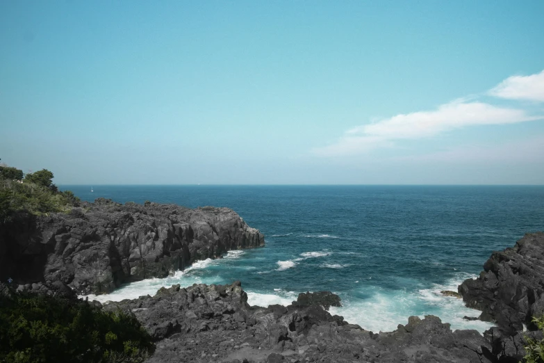 a view of the ocean from a rocky cliff, pexels contest winner, les nabis, lava rock, blue gray, low quality photo