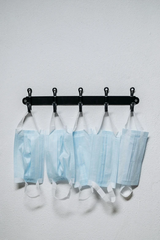 a row of surgical masks hanging on a wall, a picture, thumbnail, hammershøi, blue steel, 5 7 9