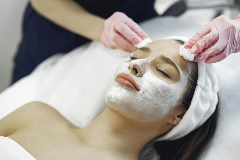 a woman getting a facial mask at a beauty salon, pexels contest winner, girl with pearl earring, thumbnail, manuka, nursing