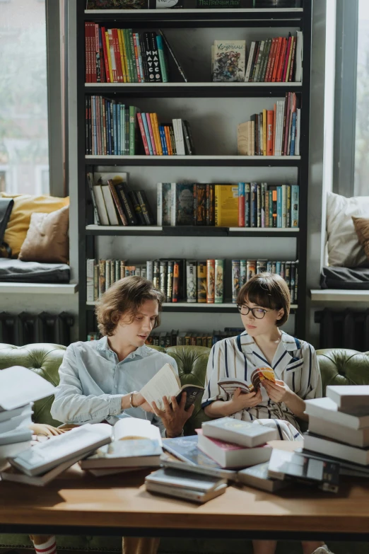 two children sitting on a couch reading books, a portrait, pexels contest winner, non-binary, bookshelves, people sitting at tables, adult pair of twins