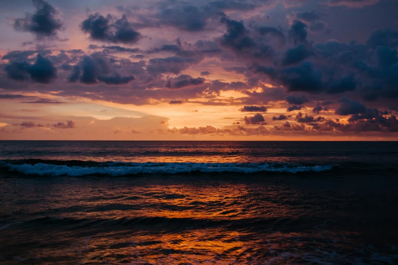 the sun sets over the ocean on a cloudy day, pexels contest winner, sri lanka, deep dark purple waters, orange / pink sky, psychedelic waves