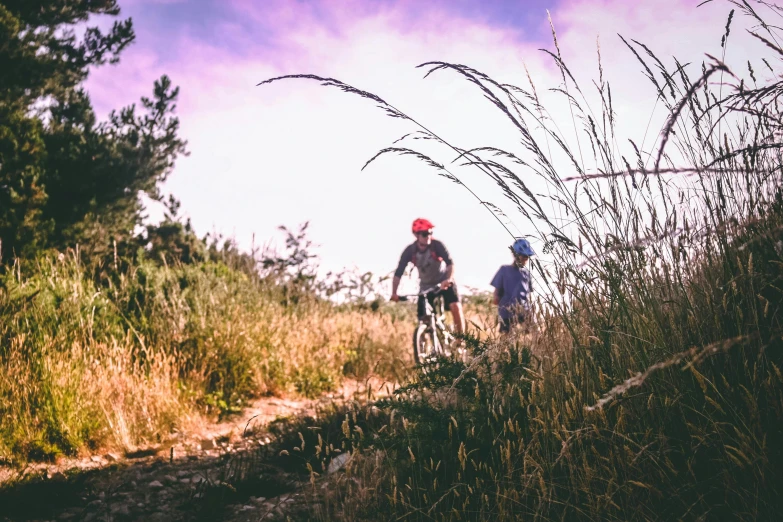 a couple of people riding bikes down a dirt road, by Lee Loughridge, unsplash, avatar image, kids, hillside, blank