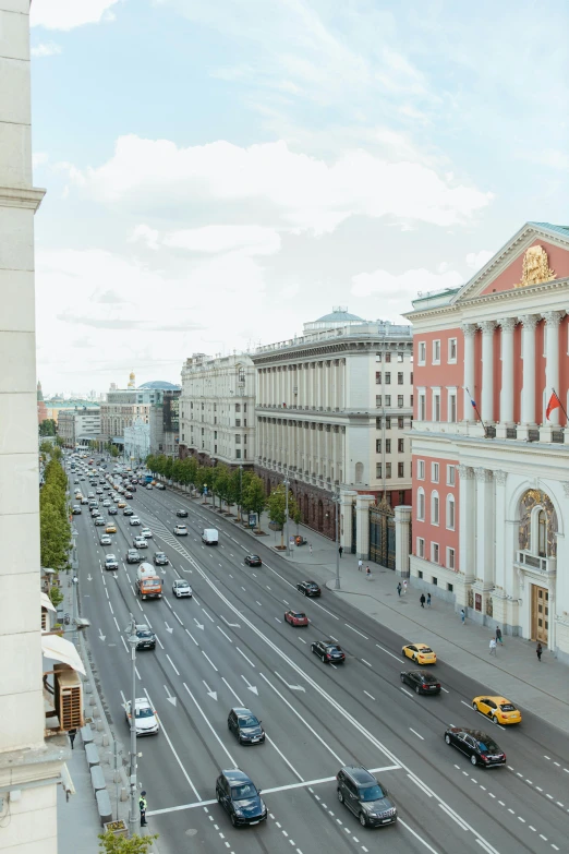 a city street filled with lots of traffic next to tall buildings, socialist realism, in moscow centre, colonnade, city views, zoomed out to show entire image