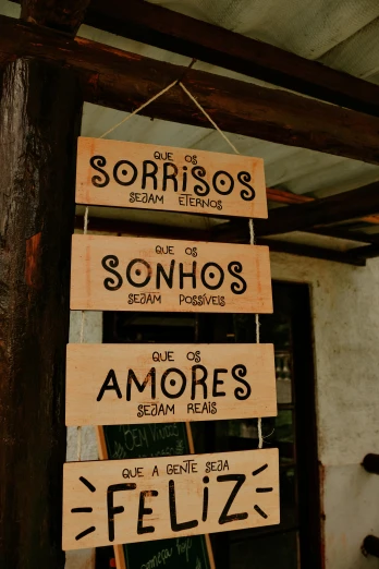 a bunch of signs hanging from the side of a building, inspired by Germán Londoño, on a wooden tray, sousaphones, they are in love, amaro