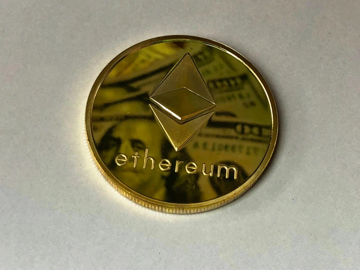 a gold coin with the word ether on it, ethereum, escher, f