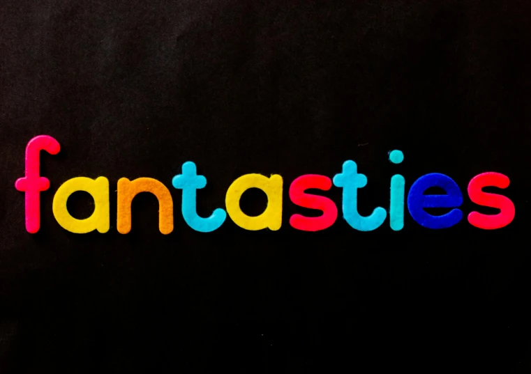a black shirt with the word fantassies written on it, an album cover, inspired by Gaston Anglade, trending on unsplash, fantastic realism, playmates toys, prismatic, bubble letters, anato finnstark. 5 0 mm