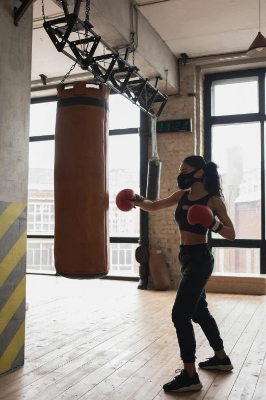 a woman standing next to a punching bag, profile image, headspace, brown, square