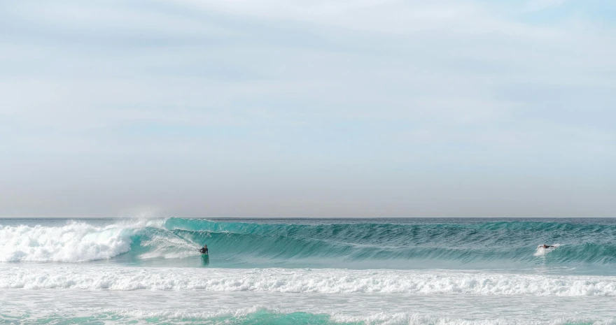 a man riding a wave on top of a surfboard, pexels contest winner, minimalism, glistening seafoam, australian beach, barrels, blue and gray colors