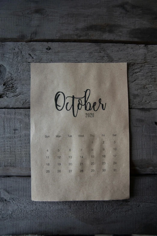 a calendar hanging on the side of a wooden wall, trending on unsplash, happening, october, on grey paper sketch ink style, thumbnail, foil