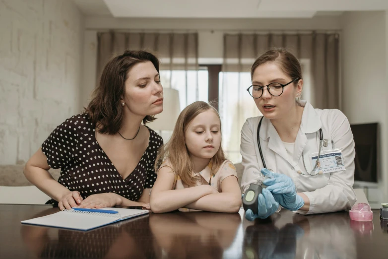 a woman and two young girls sitting at a table, pexels, hyperrealism, medical doctor, inspect in inventory image, thumbnail