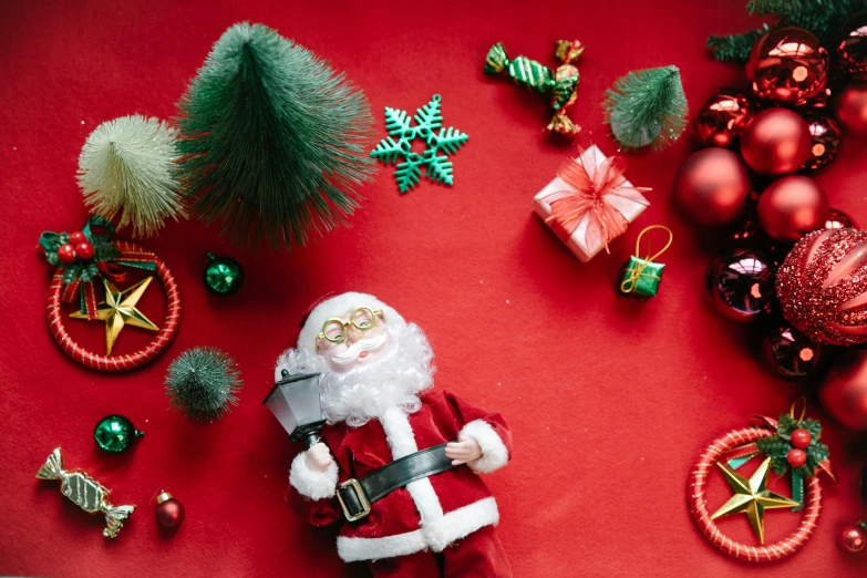 a santa claus figurine surrounded by christmas decorations, pexels contest winner, knolling, red carpeted floor, avatar image, kids