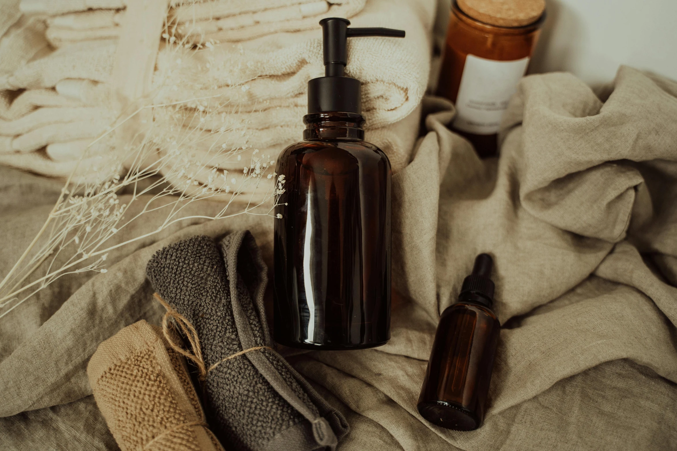 a bottle of lotion sitting on top of a bed, by Julia Pishtar, pexels contest winner, renaissance, natural materials, brown robes, first aid kit, textured base ; product photos