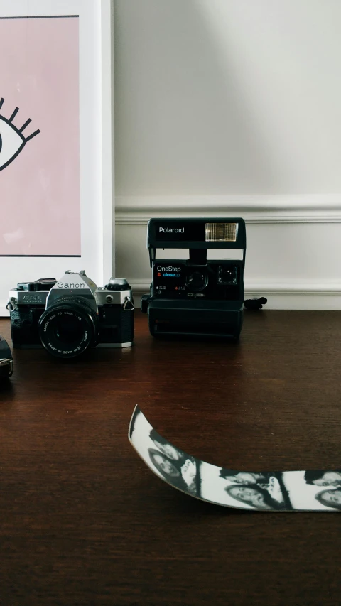 a couple of cameras sitting on top of a wooden table, a polaroid photo, unsplash, visual art, an 80's bedroom, high quality photo, on hasselblaad, toy photography