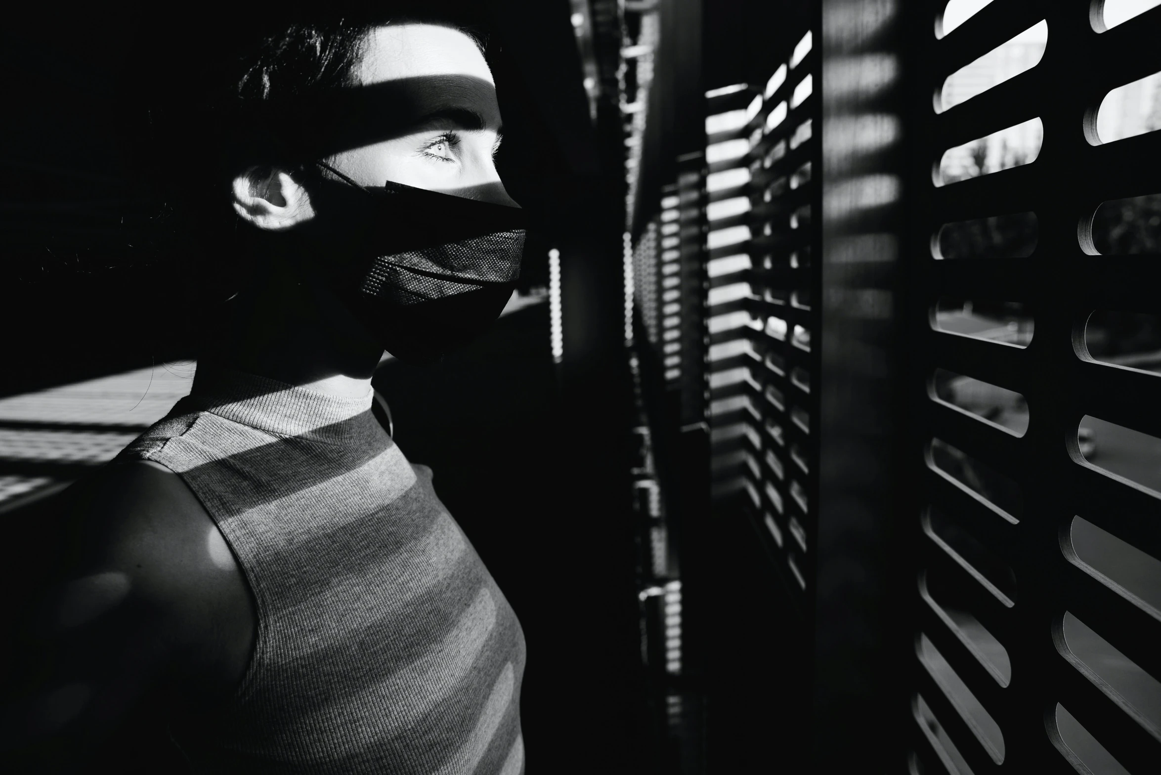 a black and white photo of a man wearing a mask, a black and white photo, pexels contest winner, standing in a server room, female thief, striped, ninja