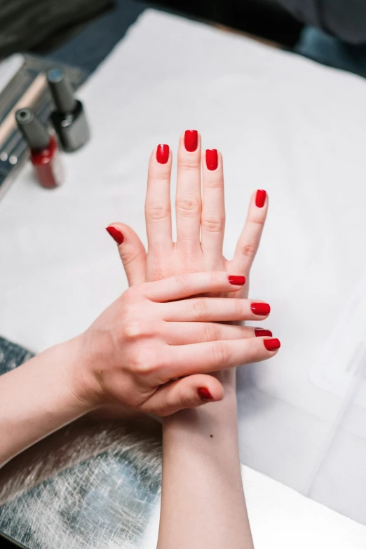 a woman getting her nails done at a salon, by Gavin Hamilton, trending on unsplash, visual art, red, close-up of thin soft hand, ap news photo, photo of a model