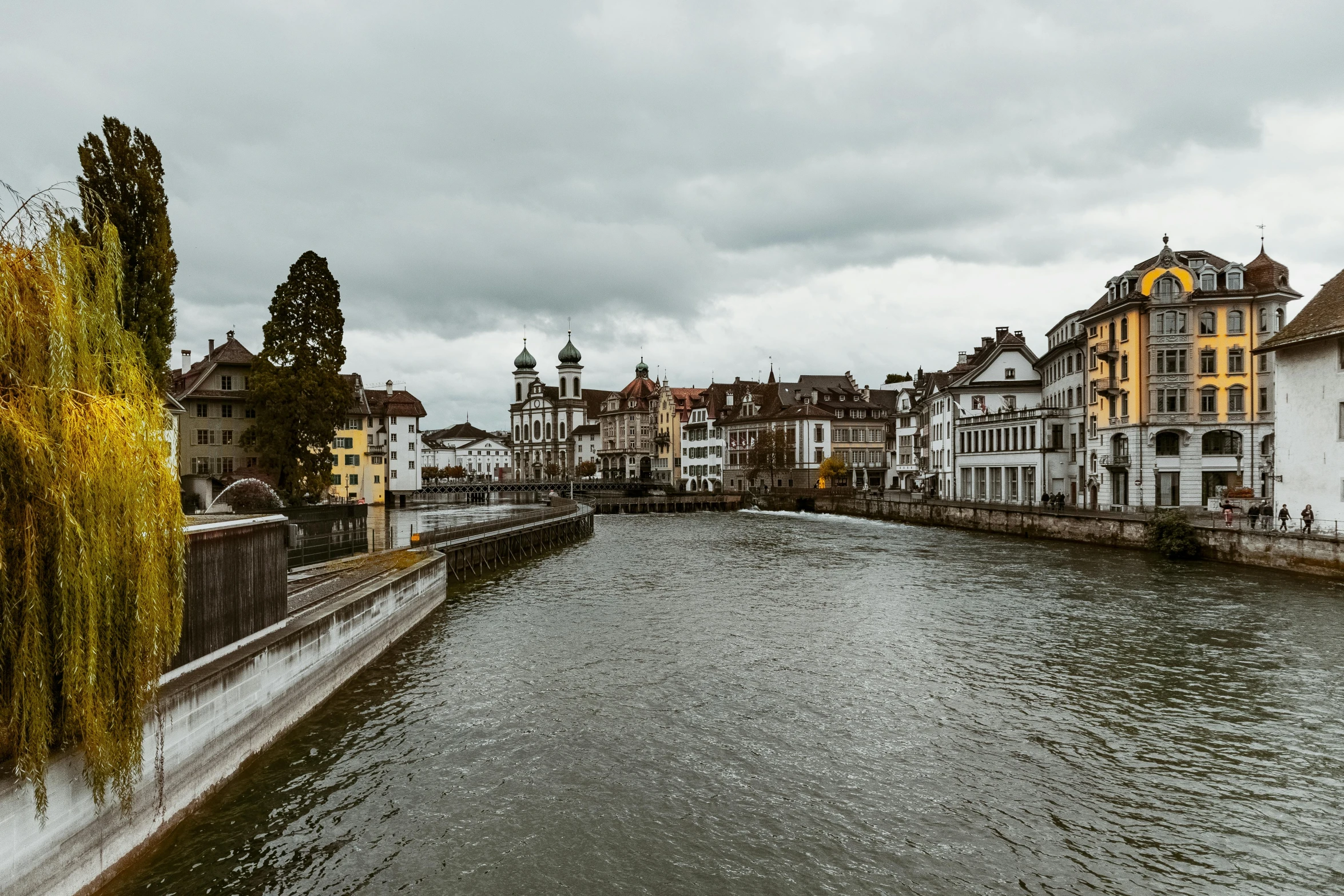 a river running through a city next to tall buildings, by Tobias Stimmer, pexels contest winner, renaissance, grossmünster, overcast gray skies, waterfront houses, hd footage