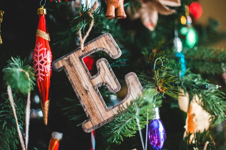 a close up of a christmas tree with ornaments, inspired by Ernest William Christmas, pexels, detailed letters, wooden, teen elf, z ed